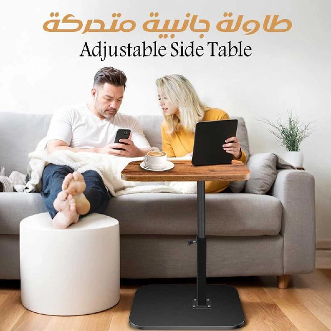 An adjustable height side table with a wooden top and black metal frame, shown in a living room setting with a couple sitting on a gray sofa. The image includes text overlays reading 'Adjustable Side Table' and Arabic text at the top.