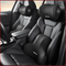 Car interior with black headrest and shoulder support pillows on gray seats.