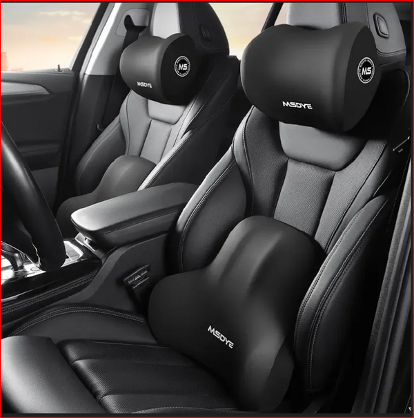 Car interior with black headrest and shoulder support pillows on gray seats.