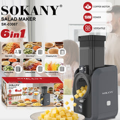 Sokany 6-in-1 salad maker SK-03087 in dark gray, shown alongside its retail box, loose yellow cheese cubes, and feature callouts for copper motor, 150W power, and versatility. The background features a softly blurred lifestyle scene of a person preparing food.