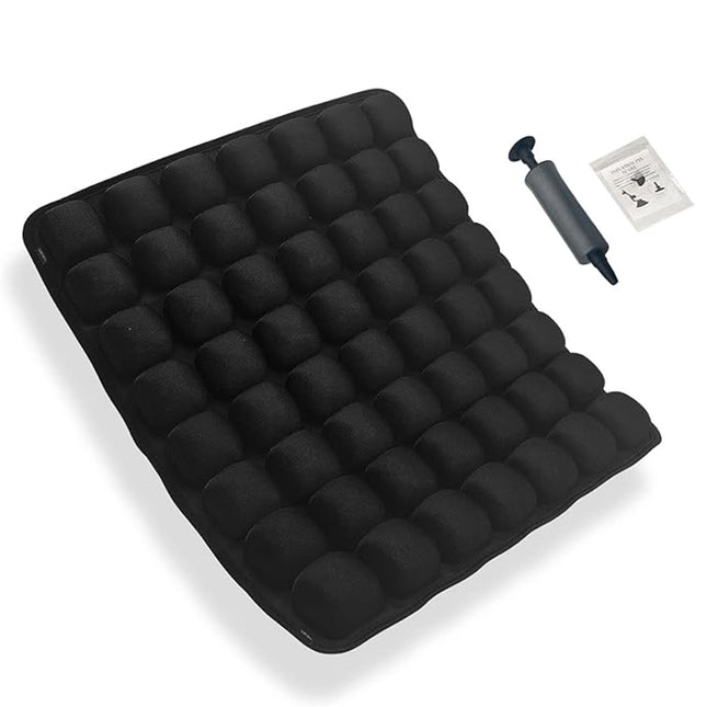 Black inflatable air mattress with a grid of bubble chambers, shown with a black hand pump and a small instruction booklet on a white background.